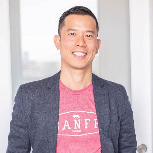 Eugene Woo. A gentleman with short hair wearing a Banff t-shirt under a jacket.